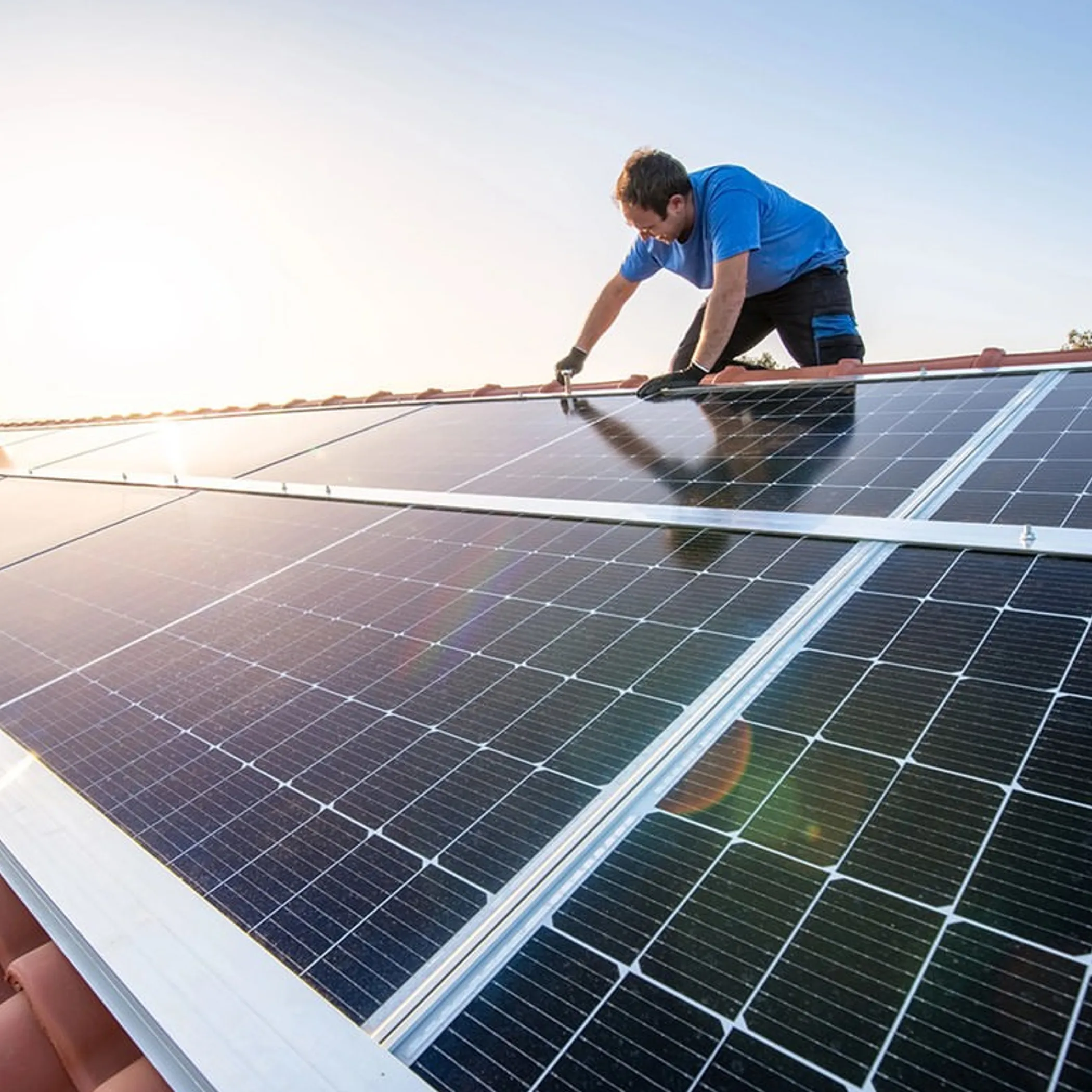 worker cleaning rooftop solar panels